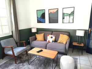 a living room with a couch and a coffee table at Magnolia Cottage in Maisons-Laffitte