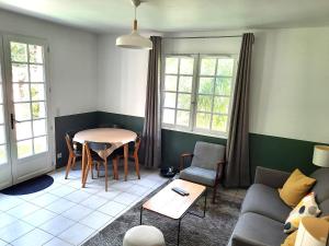 Magnolia Cottage في ميزون لافيت: غرفة معيشة مع طاولة وأريكة