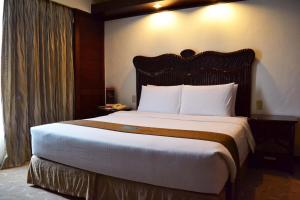 a bedroom with a large bed in a hotel room at Waterfront Airport Hotel and Casino in Mactan