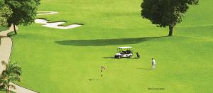 a golf cart in the middle of a green field at 2BHK, Perfect for Family, next to Mumbai Expressway, Pune in Dehu