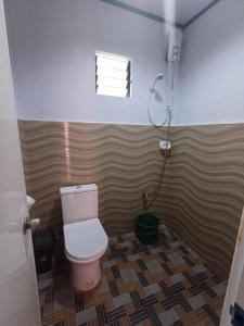 a small bathroom with a toilet and a shower at Thor's Cabin-Camp Asgard in Catarman