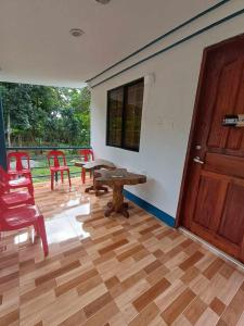 a room with a table and chairs and a door at Thor's Cabin-Camp Asgard in Catarman