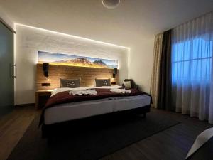 Schlafzimmer mit einem Bett mit Wandgemälde in der Unterkunft Gästehaus Seeklause in Schwangau
