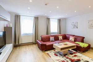 a living room with a red couch and a coffee table at Weinbau Frank Schönig in Sommerhausen