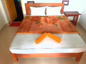 a bed with a wooden frame with orange flowers on it at 1to1 Cottage Ella in Ella