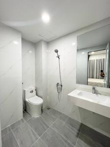 La salle de bains blanche est pourvue de toilettes et d'un lavabo. dans l'établissement Beachfront House Nha Trang, à Nha Trang