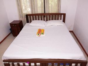 a bed with two flip flops on top of it at Villa Hasi in Habaraduwa Central