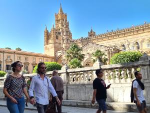 a group of people walking in front of a building at La Loggia dei Re in Palermo