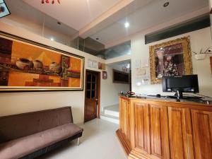 a living room with a couch and a tv on a wall at Illari Wari II-Hotel Sauna in Ayacucho