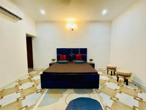 a large room with a bed and two chairs at Centaurus Pvt. villa with lawn in Noida