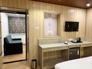 a room with a bed and a sink and a tv at Wabi Sabi Stays - Pride Inn in Mussoorie
