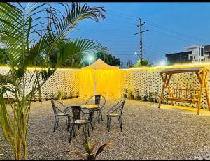 a patio with a table and chairs and a yellow wall at Centaurus Pvt. villa with lawn in Noida