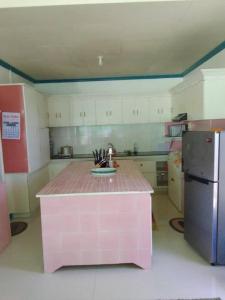 een keuken met een roze eiland in het midden bij Joy o hoy beachfront house in Santander