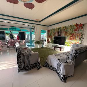een woonkamer met 2 bedden en een flatscreen-tv bij Joy o hoy beachfront house in Santander
