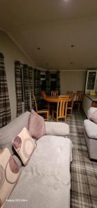 a living room with a couch and a table and chairs at Castlewood lodge in Banchory