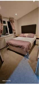 a bedroom with a large bed and a window at Castlewood lodge in Banchory