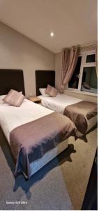 A bed or beds in a room at Castlewood lodge