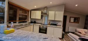 a kitchen with white cabinets and a counter top at Castlewood lodge in Banchory