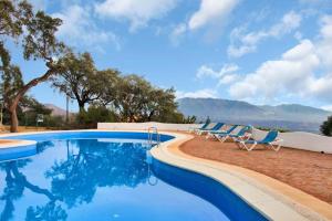 een zwembad met stoelen en uitzicht op de bergen bij Selecta - Dream Apartment in Marbella in La Mairena