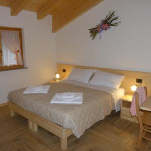 ein Schlafzimmer mit einem Bett mit zwei Handtüchern darauf in der Unterkunft Agriturismo Fattoria Dalcastagnè in Torcegno