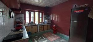 eine Küche mit roten Wänden und einem Kühlschrank in der Unterkunft The Himalayan Guest House in Skardu