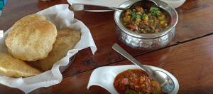 a table with a bowl of soup and some bread at Natural Lake View Hotel in Udaipur