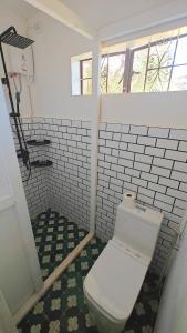 een badkamer met een wit toilet in een kamer bij 80 Bar Hostel in Coron