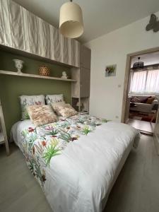 Un dormitorio con una gran cama blanca con flores. en Gites des capucins centre ville Sélestat, en Sélestat