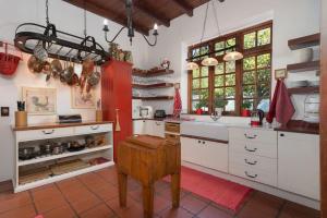 een keuken met witte kasten en een rood-witte bar bij Historical Cape Dutch Homestead in Kaapstad