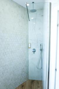 een douche met een glazen deur in de badkamer bij COSMO Beach Hotel in Durrës