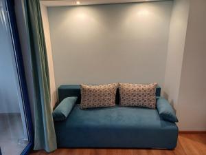 a blue couch with two pillows sitting in a room at Fenix Family Hotel in Blagoevgrad