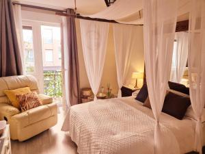 a bedroom with a canopy bed and a chair at Begutxi LVI00061 in Vitoria-Gasteiz