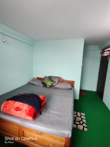 a bedroom with a bed with red and black pillows at MARYBONG HOME STAY in Darjeeling