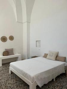 a white bedroom with a white bed in a room at L’Edicola Votiva in Casarano