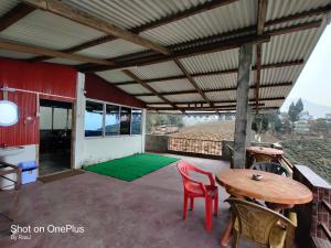 a patio with a table and chairs and a green carpet at MARYBONG HOME STAY in Darjeeling