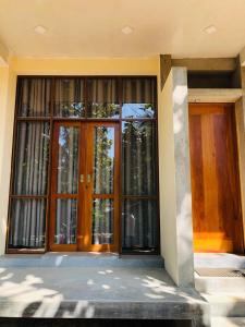 una puerta delantera de una casa con ventanas grandes en HIRI Fortress, en Dikwella