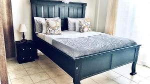 a bed with a black headboard in a bedroom at Gem in Busia