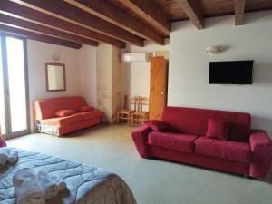 a living room with a red couch and a tv at B&B Terra Serena in Santa Cesarea Terme