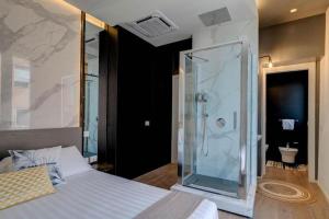 una camera con una doccia in vetro e un letto di Le Palmette Suites a Cagliari