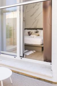 a room with a window with a bed in it at Le Palmette Suites in Cagliari