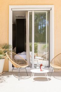 a patio with two chairs and a table and a window at Le Palmette Suites in Cagliari