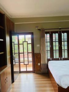 um quarto com uma cama grande e portas de vidro deslizantes em sauraha alley inn em Chitwan