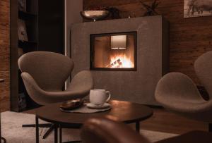 a living room with chairs and a fireplace at ASTER Boutique Hotel & Chalets in Fügenberg