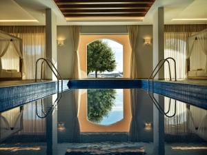 a swimming pool in a hotel room with a reflection in the water at The Chedi Luštica Bay in Tivat