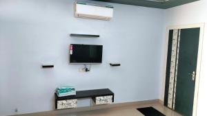 a living room with a tv on a white wall at Unique Couple Friendly Stay in Morbi