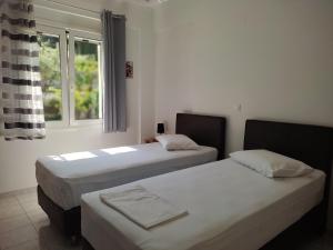 dwa łóżka w pokoju z oknem w obiekcie Korakias SeaView w mieście Yénion