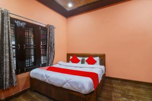 um quarto com uma cama grande e almofadas vermelhas em OYO Hari Leela Home Stay em Haldwani