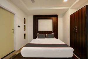 1 dormitorio con 1 cama blanca grande frente a una ventana en Blubell Rengoni, en Guwahati