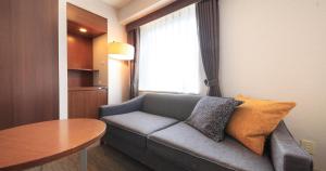a living room with a couch and a table at Richmond Hotel Tokyo Shiba in Tokyo