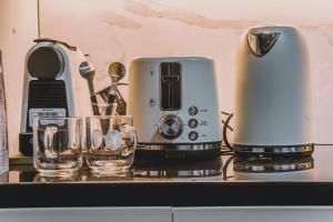 a coffee maker and two glasses on a counter at Saint Honore Studio Retreat with Amenities in Iloilo City
